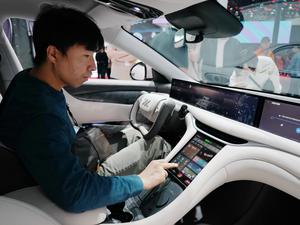 Ein Besucher sitzt im neuen Energiefahrzeugmodell von IM Motors auf der Internationalen Automobilausstellung 2024. 