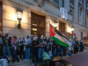 Studenten mit Palästina-Flaggen vor einem Universitätsgebäude.